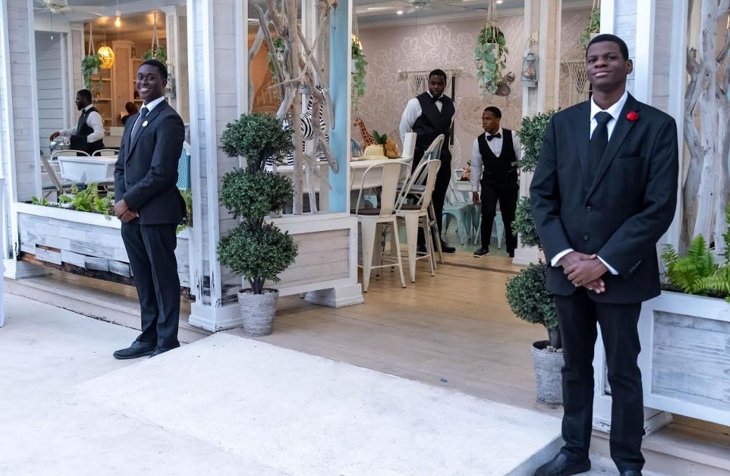 Top Tier Butlers team welcoming guests at a garden venue