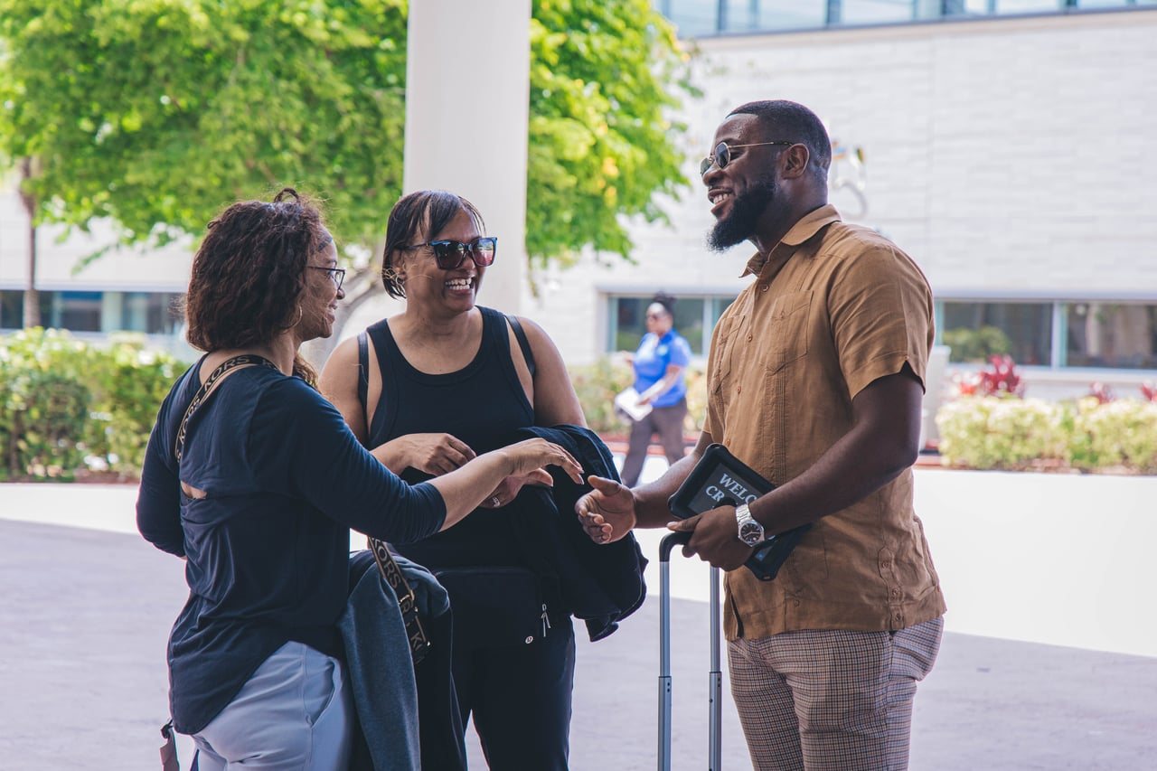 Team member welcoming guests on arrival outdoors